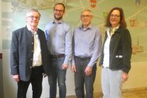 Vier Personen stehen vor einer Wand