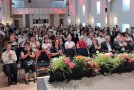 Personen sitzen in einem Saal und klatschen
