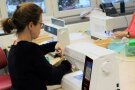 Frau sitzt an der Nähmaschine