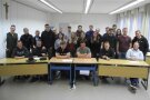 Personen befinden sich in einem Klassenzimmer