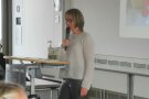 Frau steht am Rednerpult