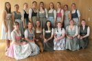 16 Frauen im Dirndl stellen sich für Foto auf