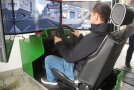 Eine junger Mann lenkt einen Fahrsimulator
