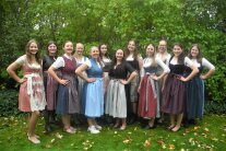 Frauen stehen im Dirndl auf einer Wiese