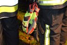 Feuerwehrhandschuhe hängen an einer Feuerwehrjacke