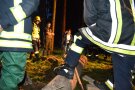 Personen stehen im Wald im Kreis und unterhalten sich