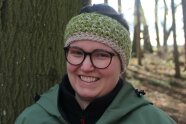 Frau steht vor Baum