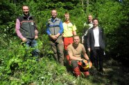 sechs Männer stehen für ein Gruppenfoto im Wald