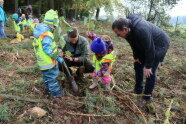 Kindergartenkinder pflanzen mit Bürgermeister und Förster Bäume