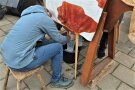 Frau melkt eine Kuhattrappe mit Gummieuter