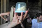 Hand hält ein Glas mit Butter hoch
